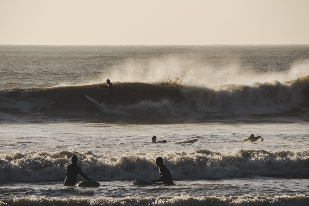 波の上でサーフボードに乗る人々のグループ