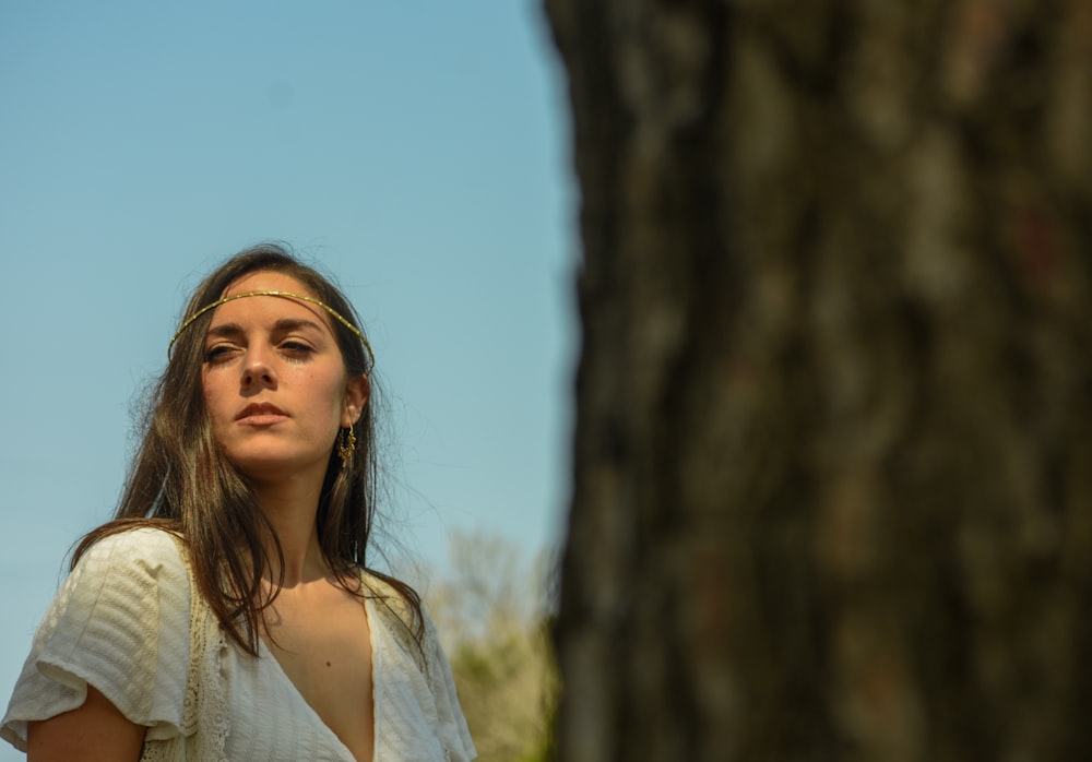 a woman standing in front of a tree