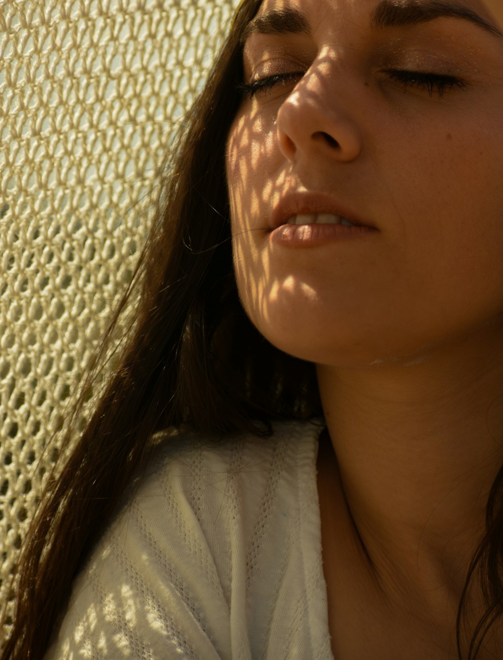 a woman laying down with her eyes closed