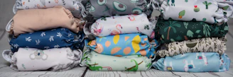 a stack of cloth diapers sitting on top of a wooden floor