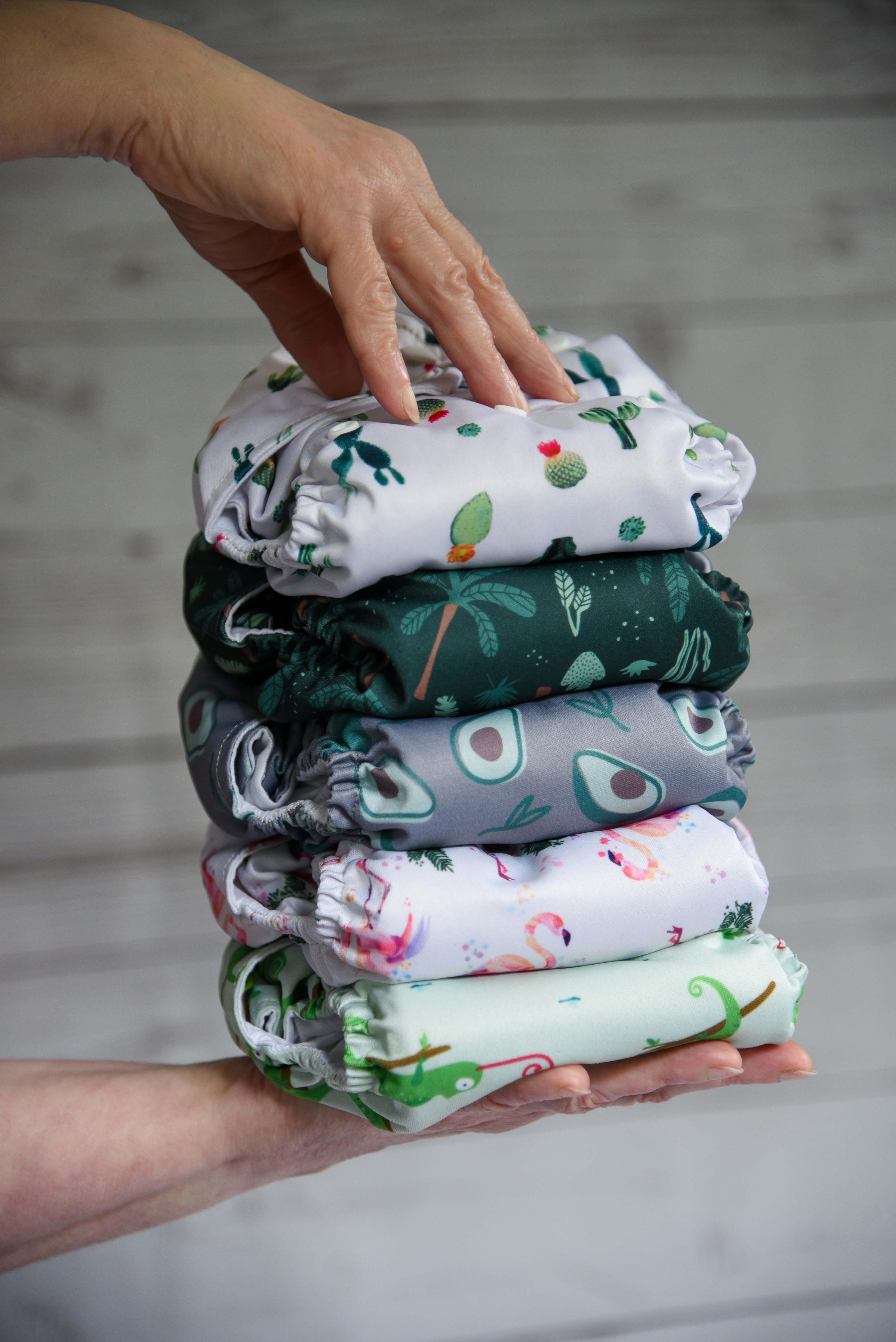 a person holding a stack of folded cloths