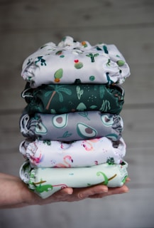 A happy customer holding a stack of colorful linens with a bright smile.
