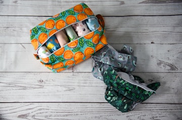an orange and green bag and a pair of scissors