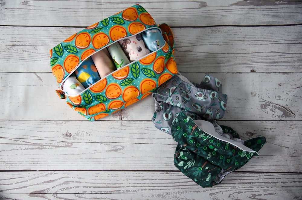 an orange and green bag and a pair of scissors