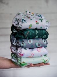 a person holding a stack of cloths in their hand