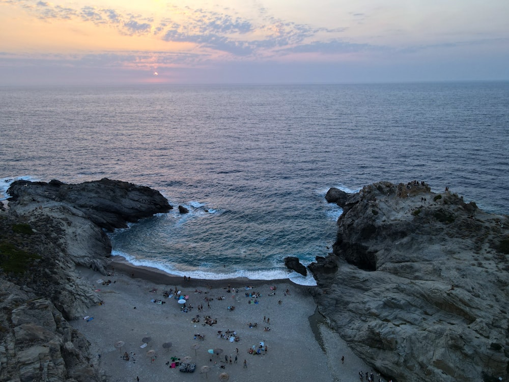 Un grupo de personas de pie en la cima de una playa junto al océano