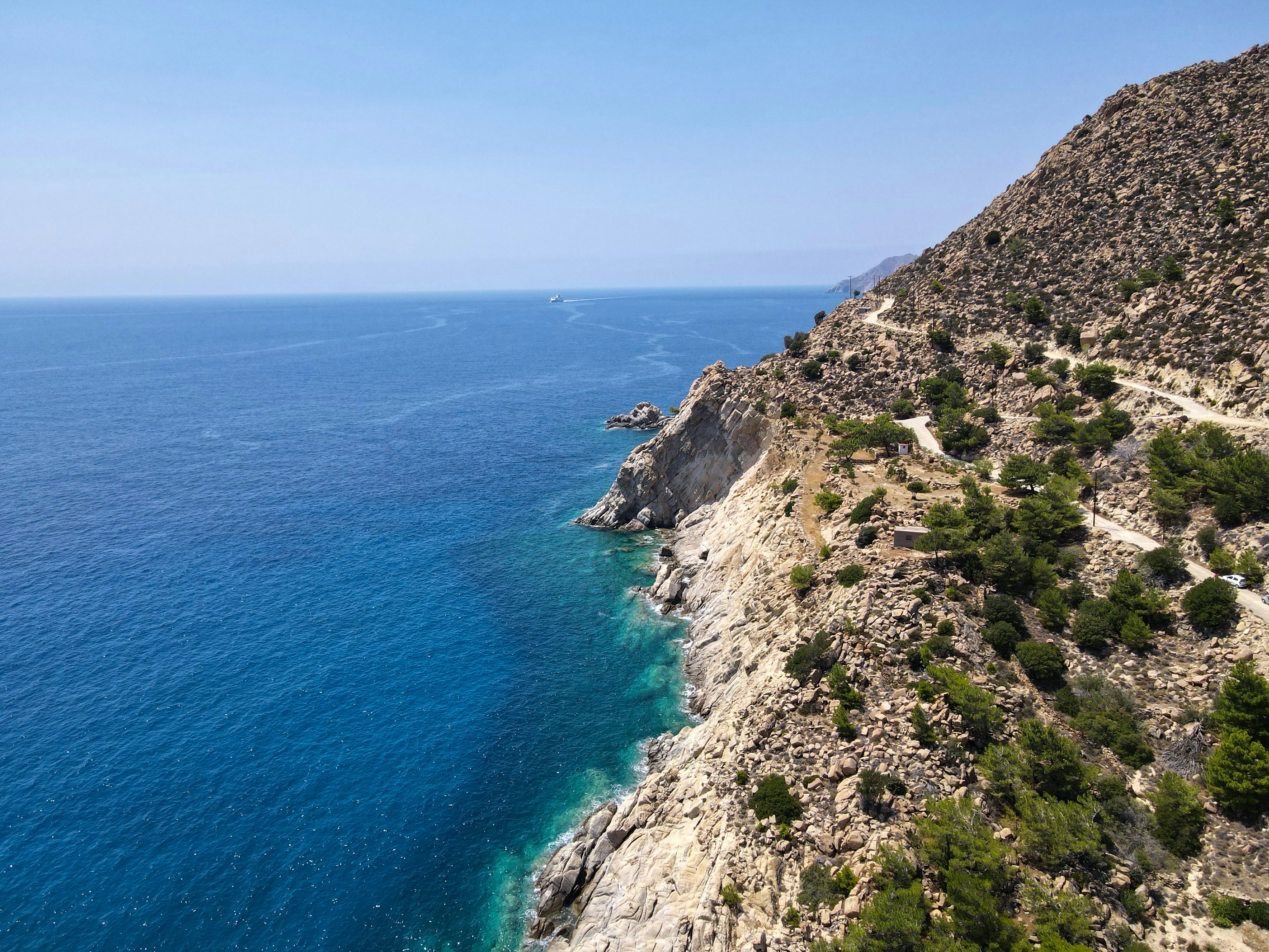 a view of the ocean from a cliff, A view above Trapalou beach, Ikaria island, Greece.