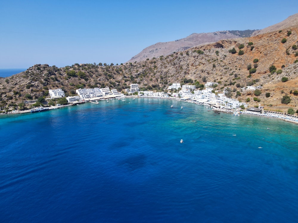 an aerial view of a blue ocean with white buildings