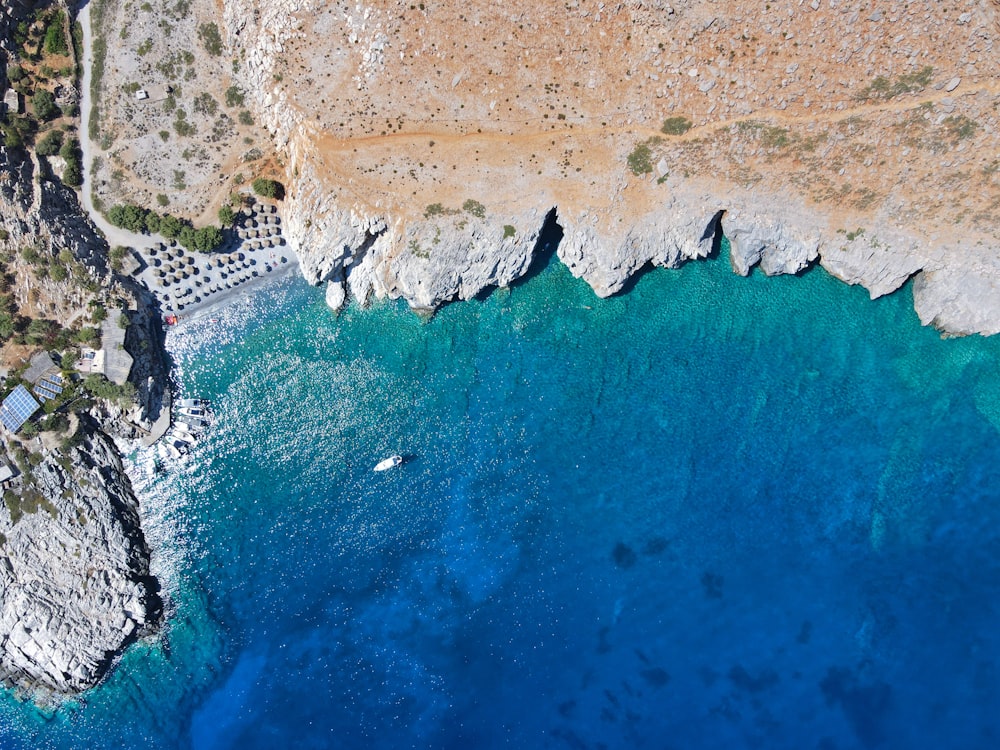 an aerial view of a beach with a boat in the water