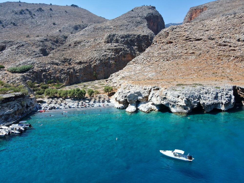 a boat is in the water near a rocky shore