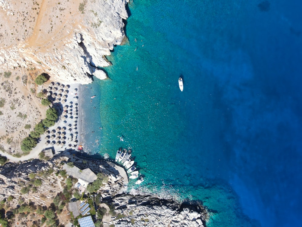 an aerial view of a beach with boats in the water