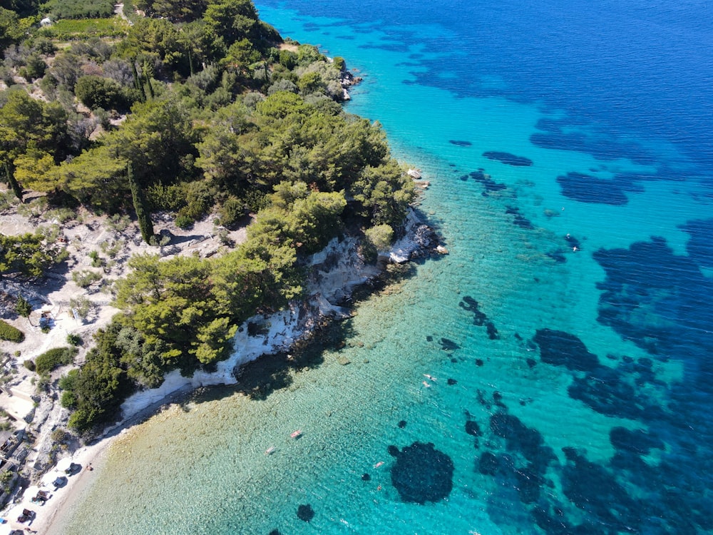 an aerial view of a beach with clear blue water