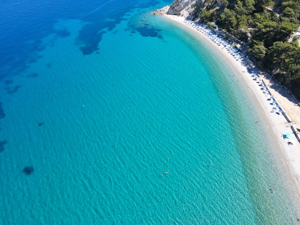 an aerial view of a beach with clear blue water