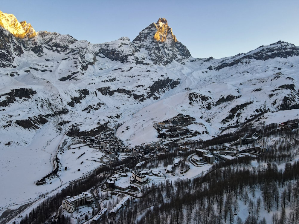 ein schneebedeckter Berg mit einem Dorf im Vordergrund