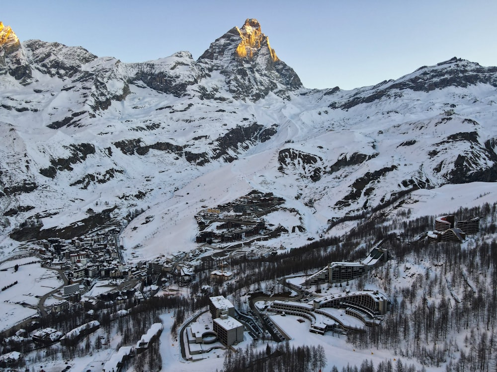 ein schneebedeckter Berg mit einem Dorf im Vordergrund