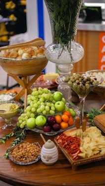 A warm, inviting scene of a beautifully arranged grazing table with colorful cheeses, meats, fruits, and fresh flowers.