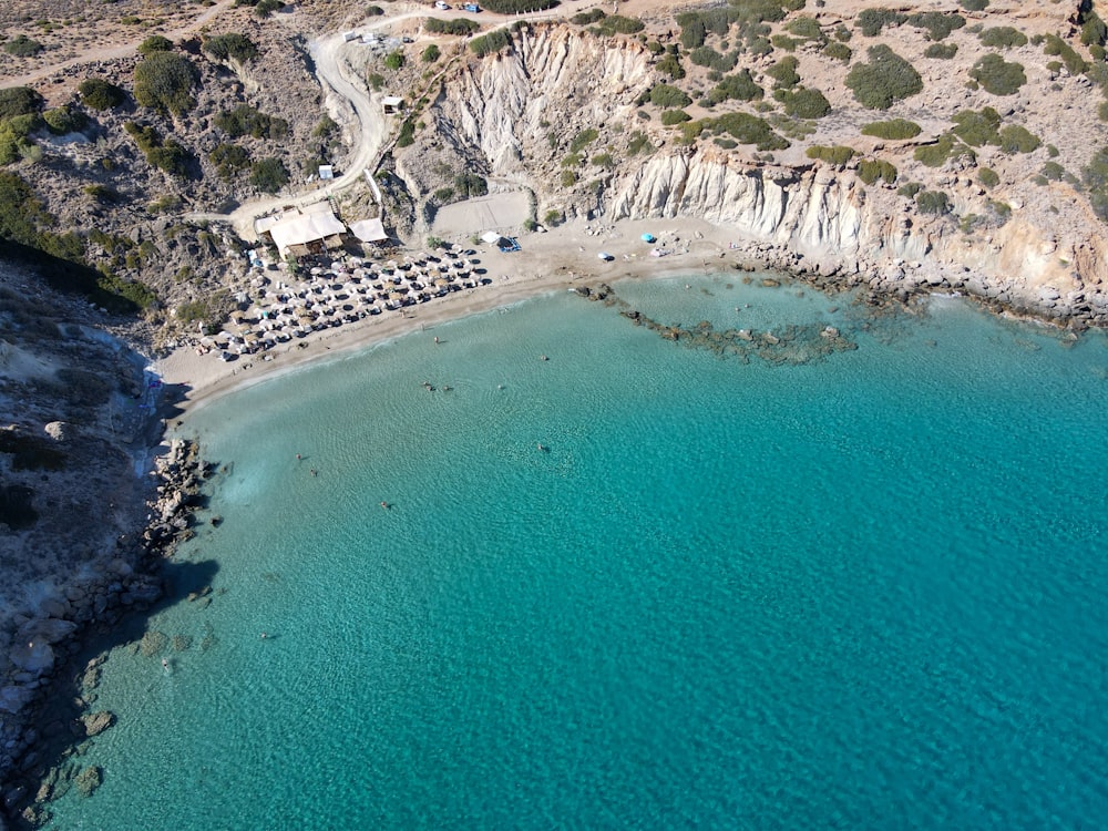 an aerial view of a beach with a cliff in the background