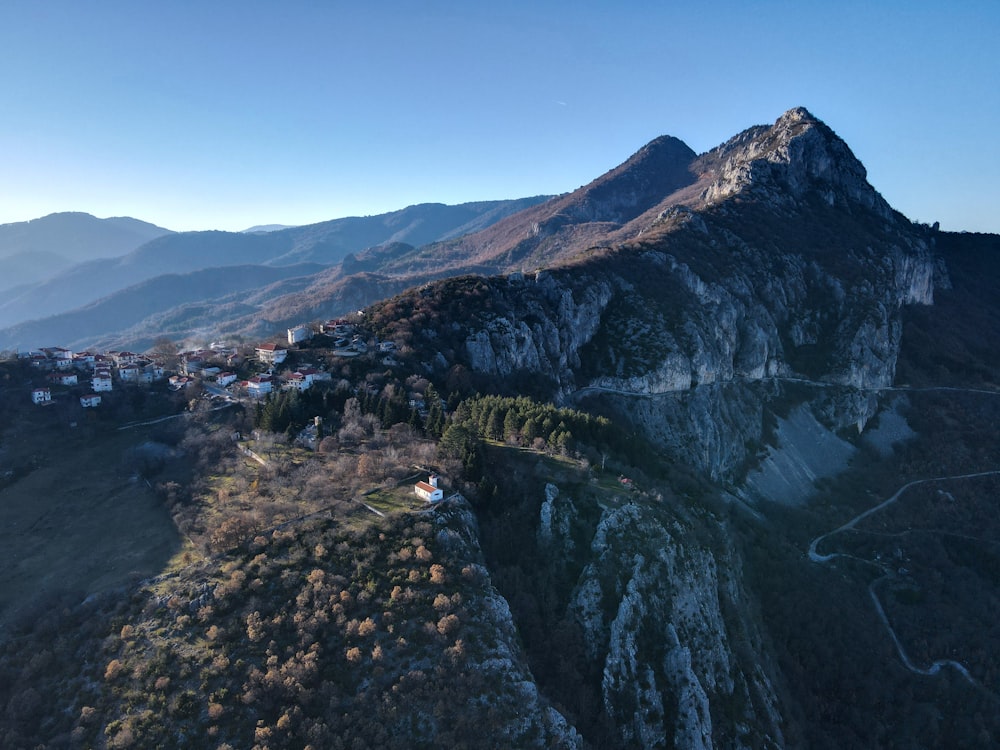 uma vista aérea de uma montanha com uma aldeia no topo