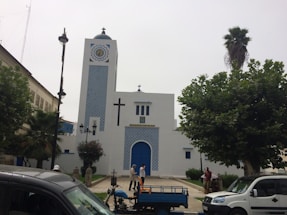 A welcoming campus entrance with a cross and students walking nearby.