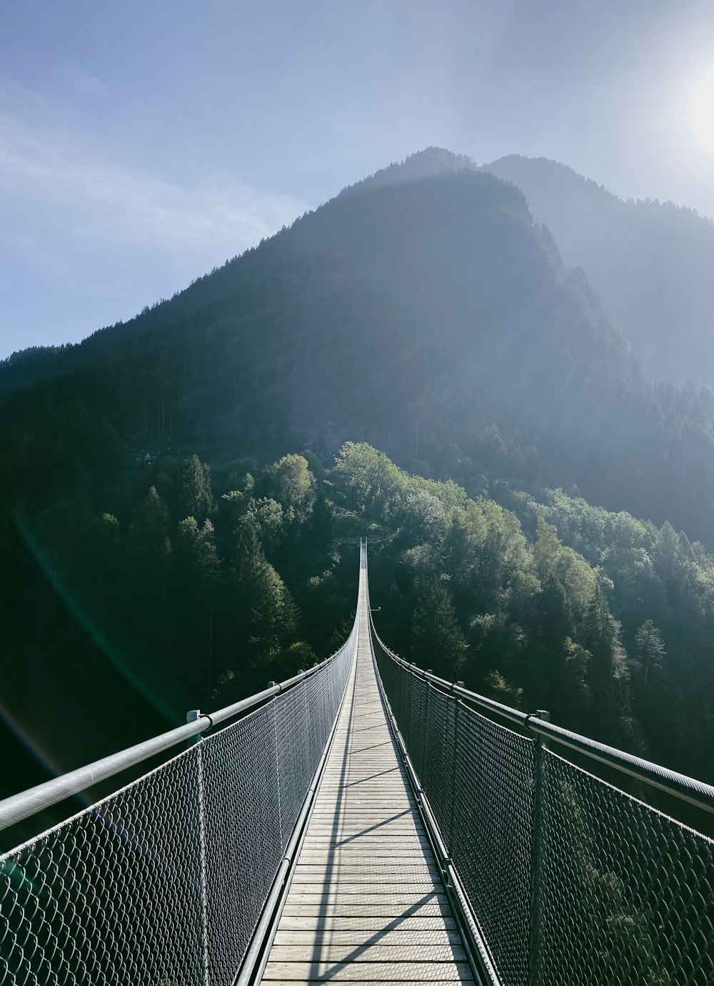 a long suspension bridge with a mountain in the background