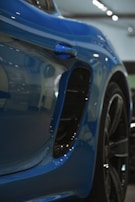 Artistic angle showing the contrast between glossy black wrap and sharp blue edging on a vehicle.