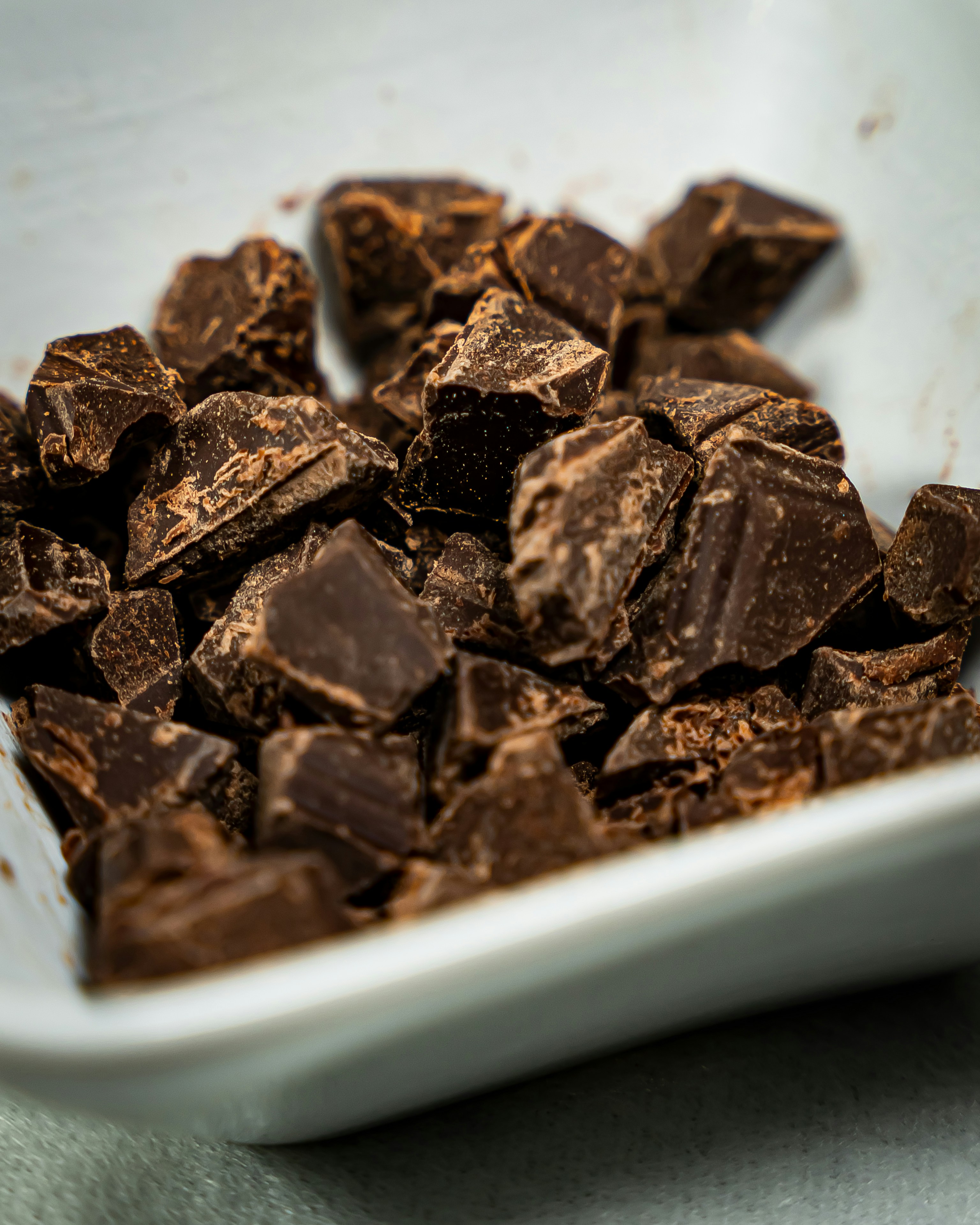 a white bowl filled with chocolate pieces on top of a table