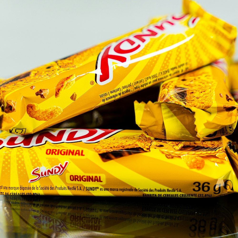 a pile of yellow candy bars sitting on top of a table