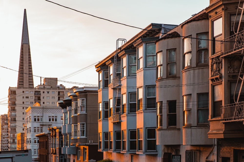 a row of buildings with a steeple in the background