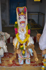 Beautifully decorated cow dung toran hanging on a vibrant doorway during a festival.
