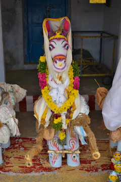 Beautifully decorated cow dung toran hanging on a vibrant doorway during a festival.