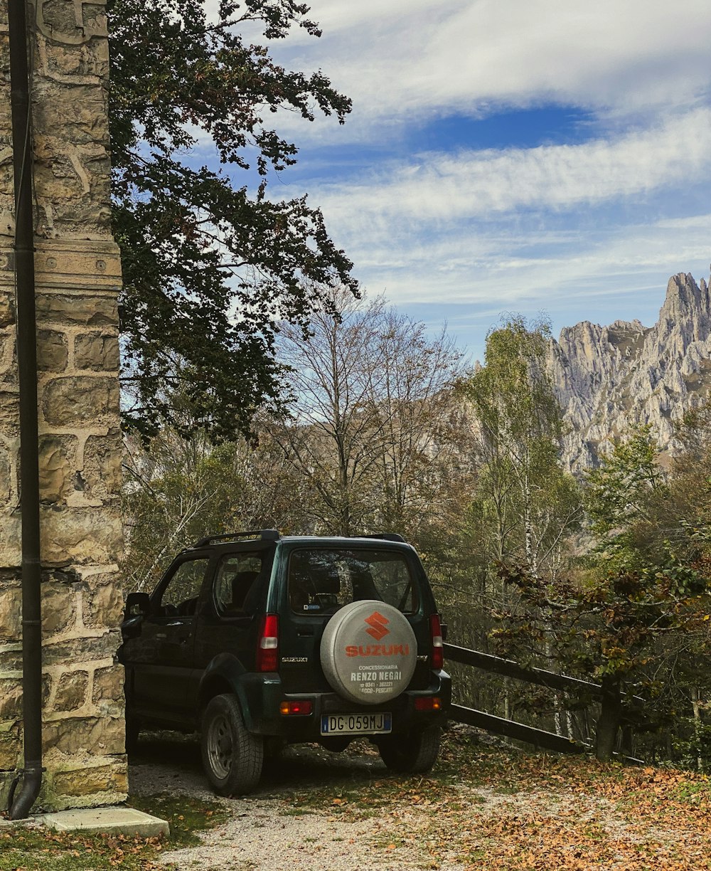 a black car parked next to a stone building