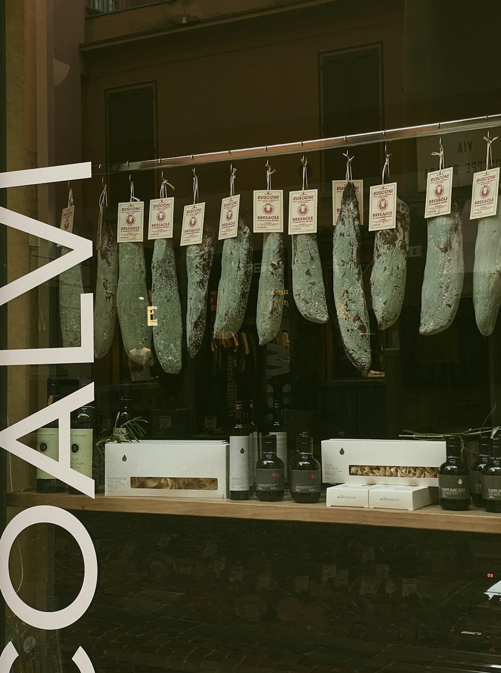 a display of meat hanging in a store window