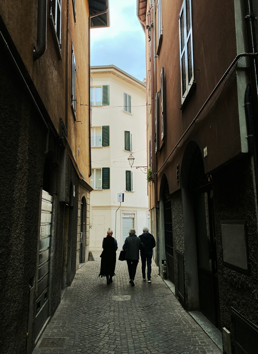 a couple of people walking down a narrow street