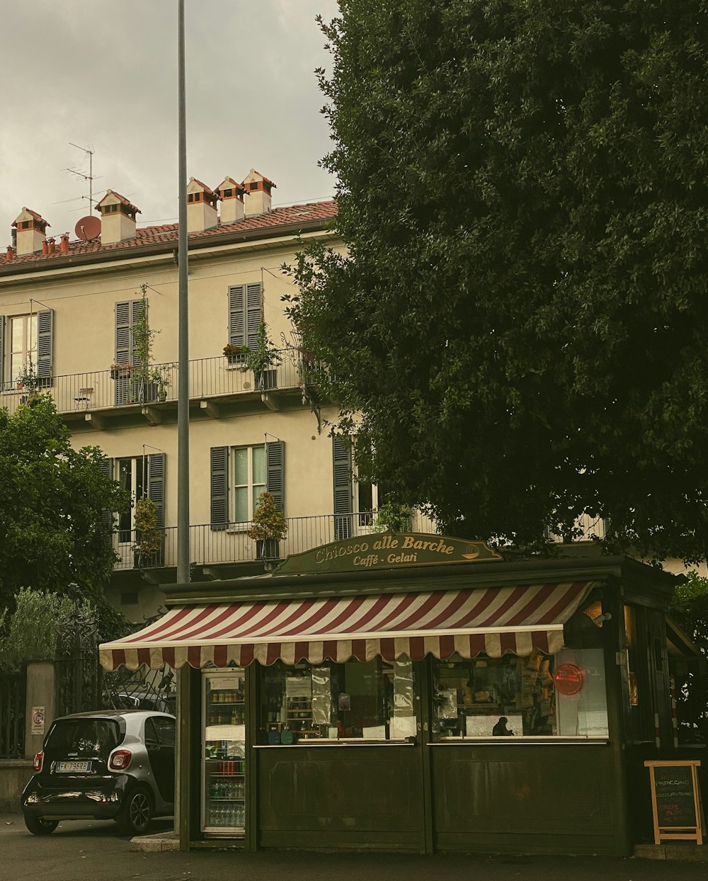 a building with a striped awning and a car parked in front of it