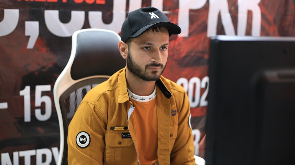 Un hombre sentado frente a un monitor de computadora