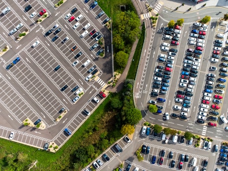 an aerial view of a parking lot with cars parked in it