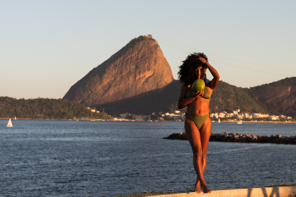 a woman in a bikini walking on the beach