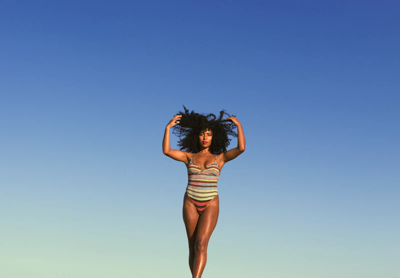 Sugar Mommy em traje de banho caminhando na praia, liberdade e charme