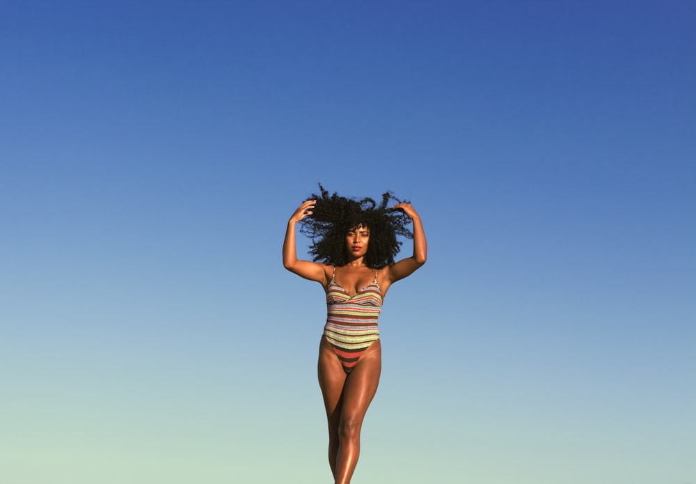 a woman in a bathing suit walking on a beach