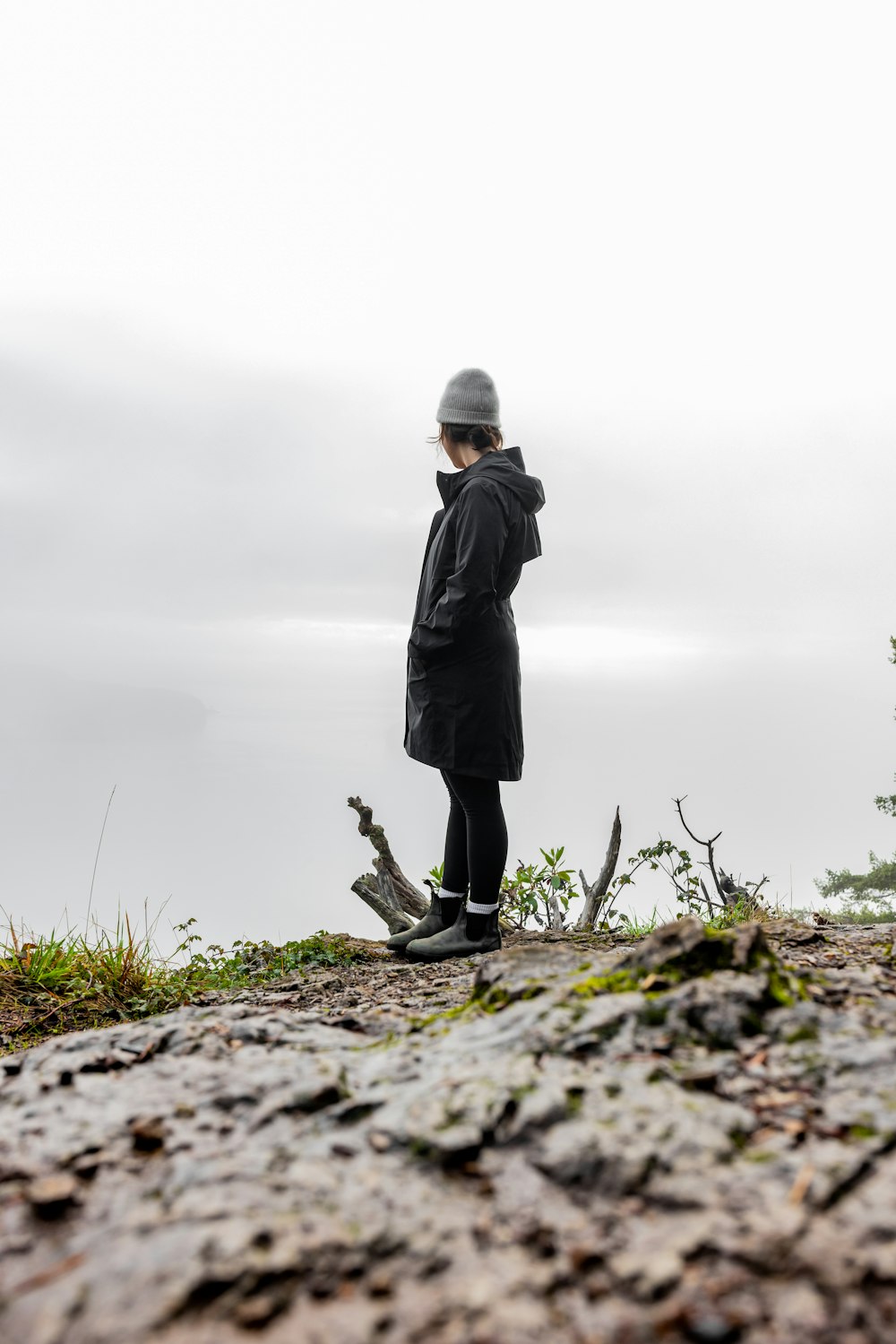 una persona in piedi sulla cima di una collina rocciosa