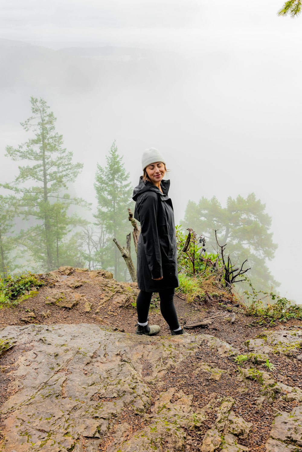 a woman standing on top of a mountain