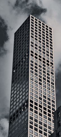 a very tall building with a very cloudy sky in the background