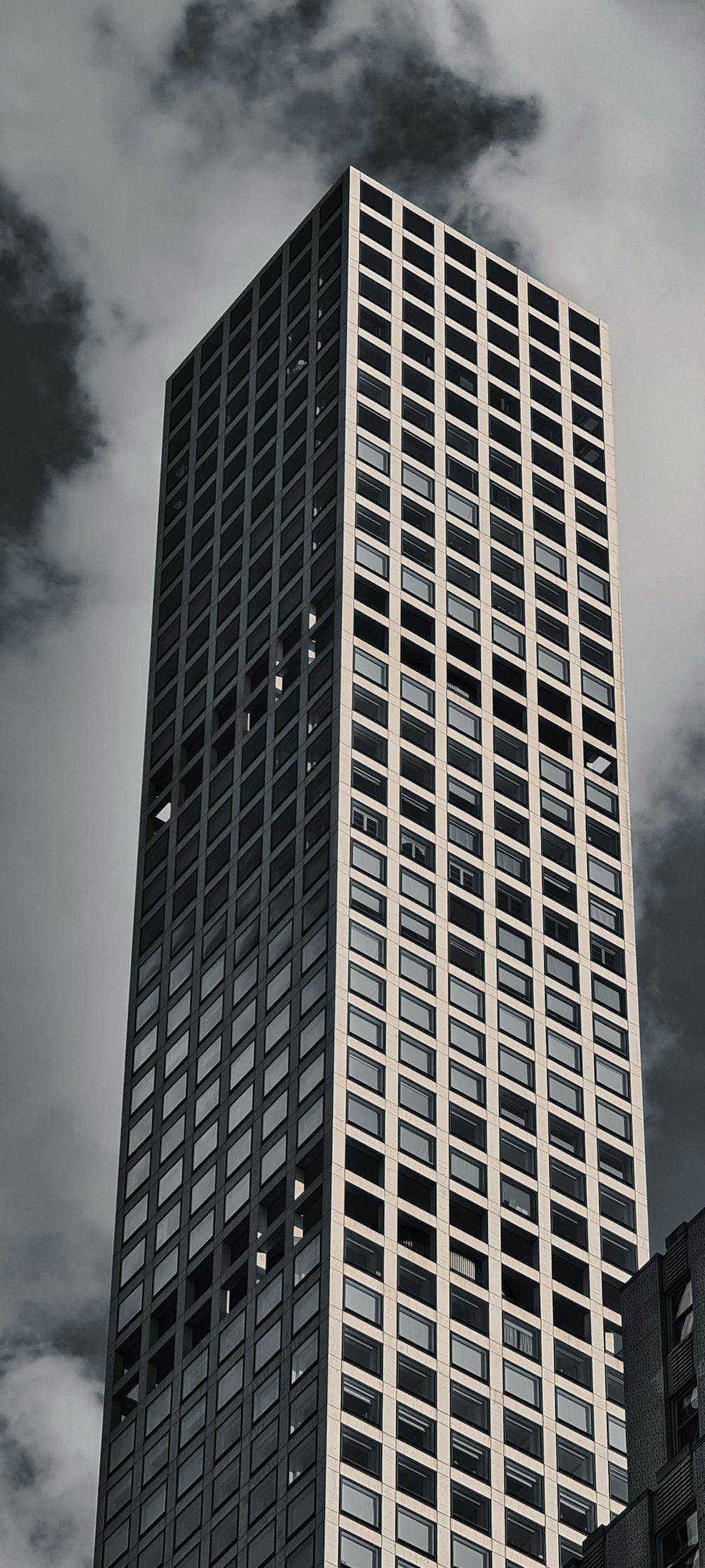 a very tall building with a very cloudy sky in the background
