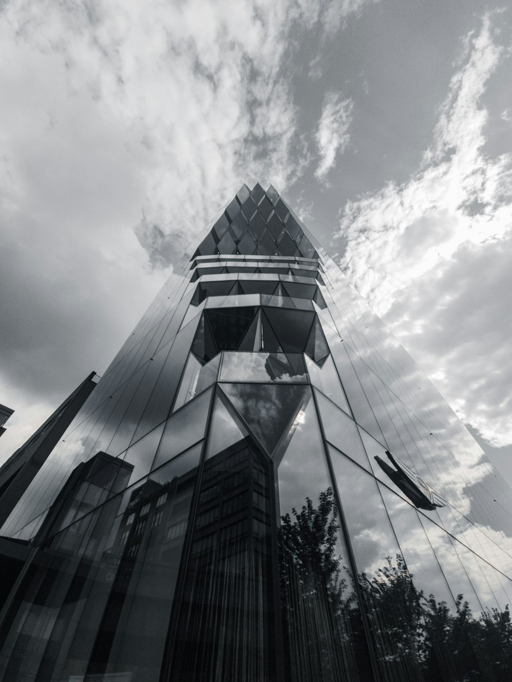 a very tall glass building with a sky background