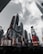 Skyscrapers rise against a cloudy sky, adorned with bright, large advertisements and digital billboards. The urban environment is dynamic, with various colorful ads promoting different brands and shows.