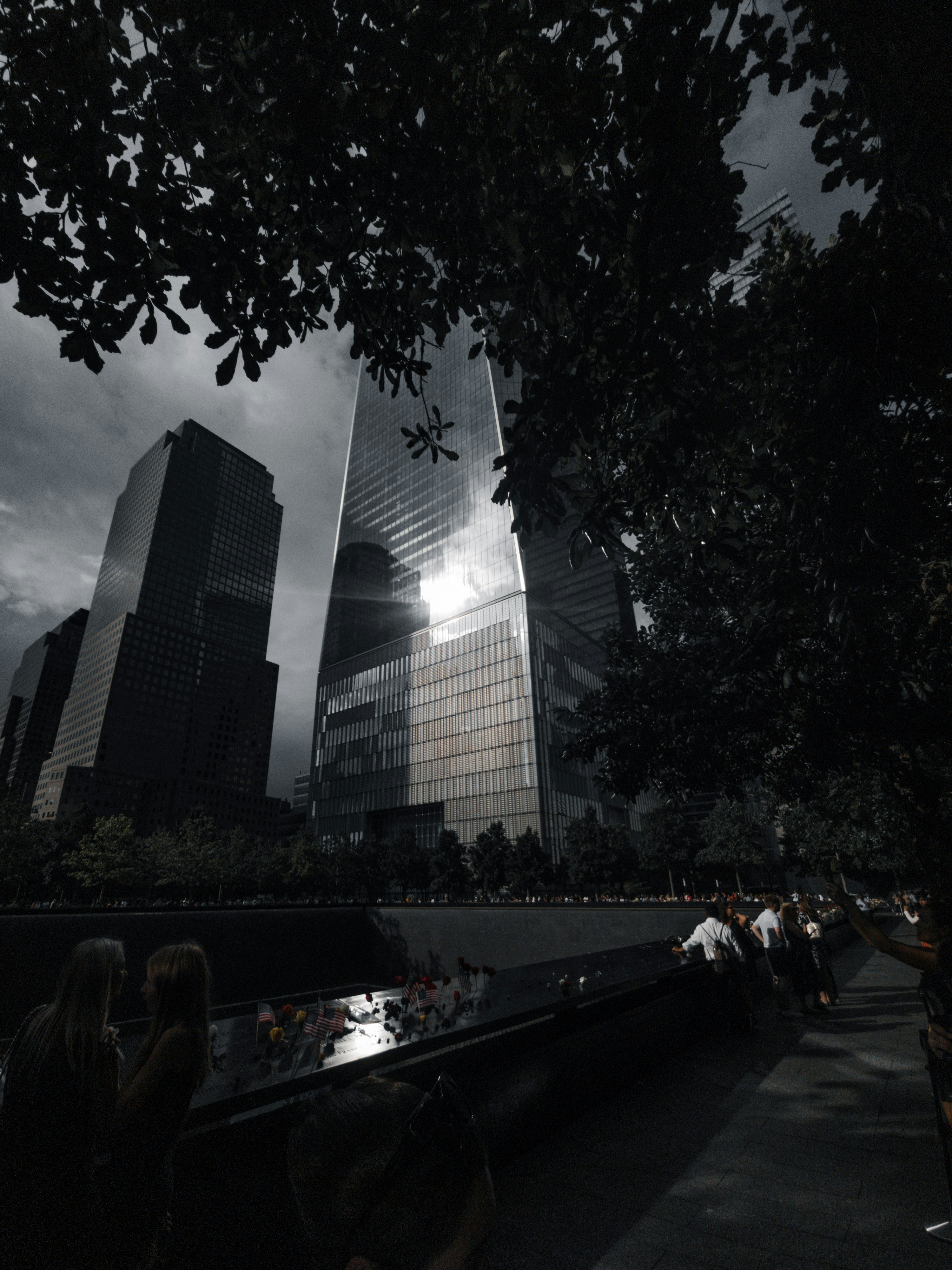 a group of people sitting next to each other near tall buildings