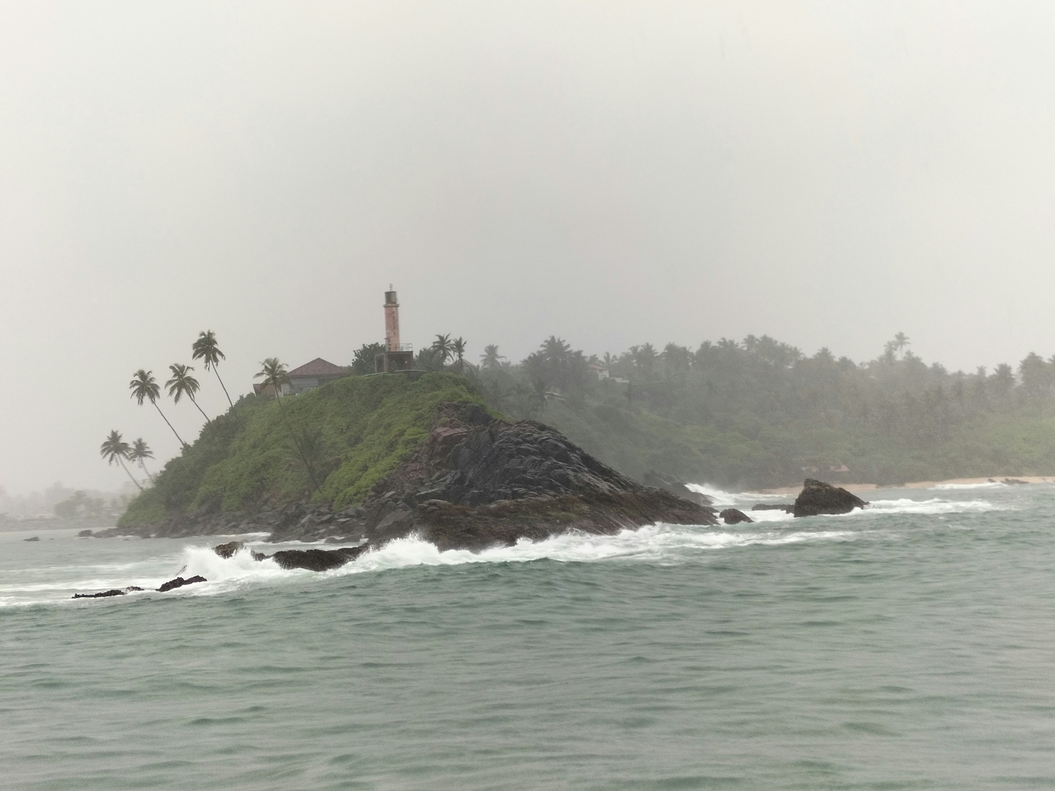 a lighthouse on a small island in the middle of the ocean