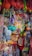 A densely packed display of assorted colorful toys hanging and stacked in a store. The items include various types of balls, rackets, action figures, dolls, and other children's playthings in vibrant packaging.
