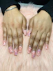 Stylish nail artist applying a delicate floral design on a client's nails in a chic studio
