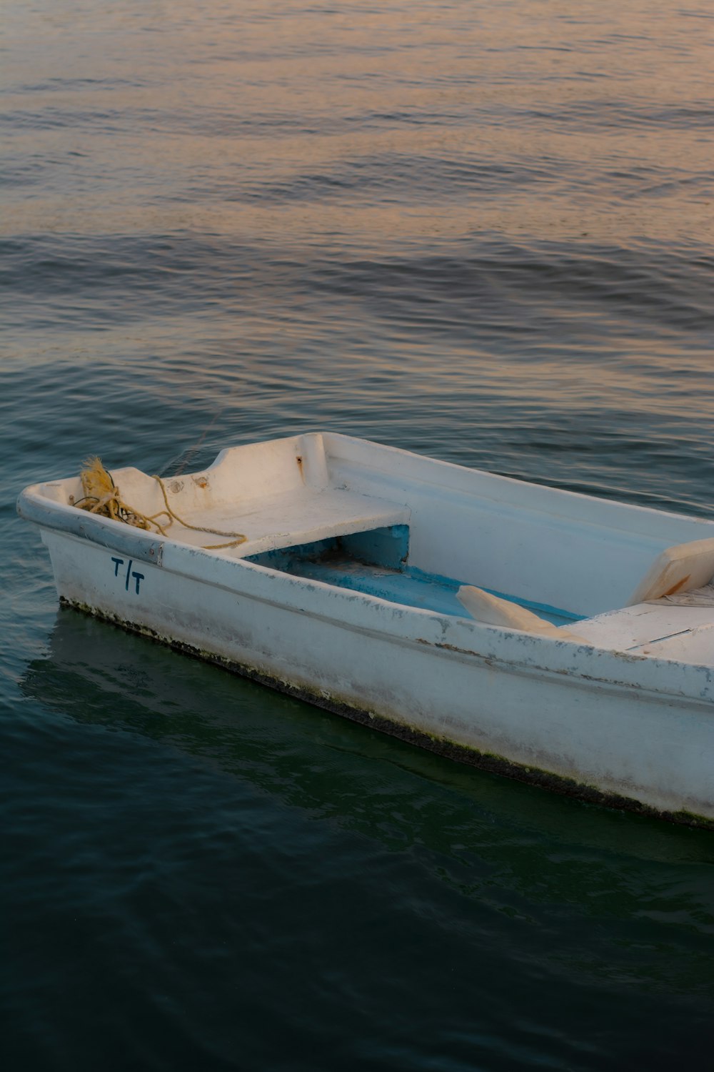 a small white boat floating on top of a body of water